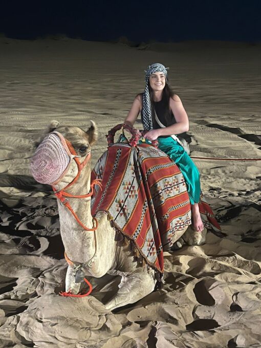 Female Tourist sitting on a camel on desert tour dubai